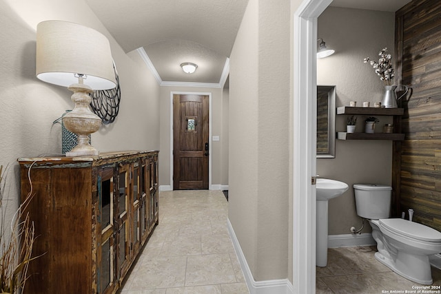 corridor featuring a textured ceiling, crown molding, and sink