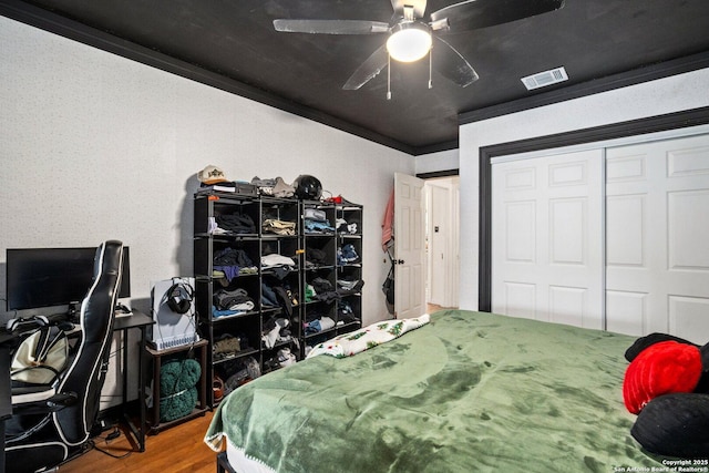 bedroom featuring ceiling fan, a closet, ornamental molding, and hardwood / wood-style flooring