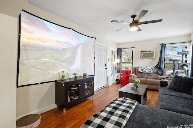 living room with dark hardwood / wood-style flooring, a wall unit AC, and ceiling fan