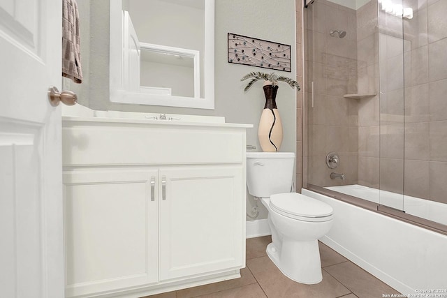 full bathroom with combined bath / shower with glass door, vanity, tile patterned floors, and toilet