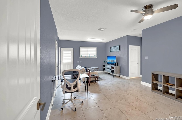 tiled office space featuring ceiling fan and a textured ceiling