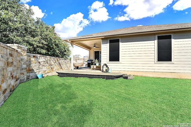 back of property featuring ceiling fan, a yard, and a patio