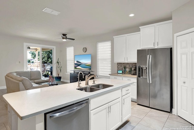 kitchen featuring white cabinets, sink, ceiling fan, an island with sink, and appliances with stainless steel finishes