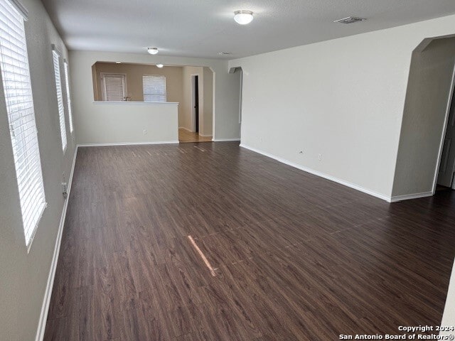 unfurnished living room featuring dark wood-type flooring