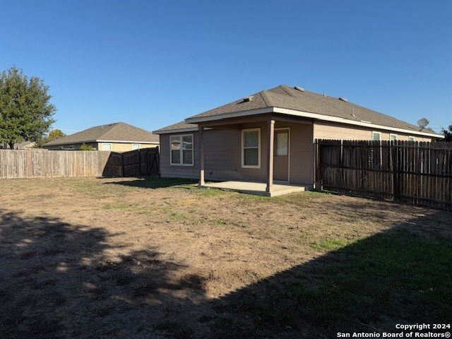 rear view of house with a lawn and a patio