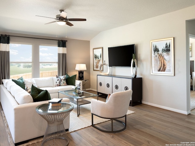 living room with wood-type flooring, a textured ceiling, vaulted ceiling, and ceiling fan