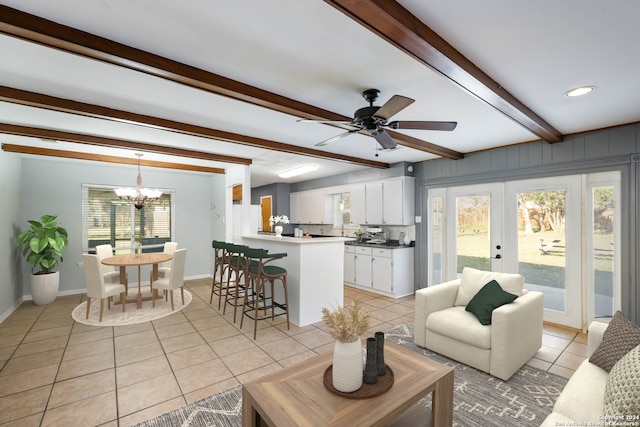 living room featuring beam ceiling, french doors, light tile patterned flooring, and ceiling fan with notable chandelier