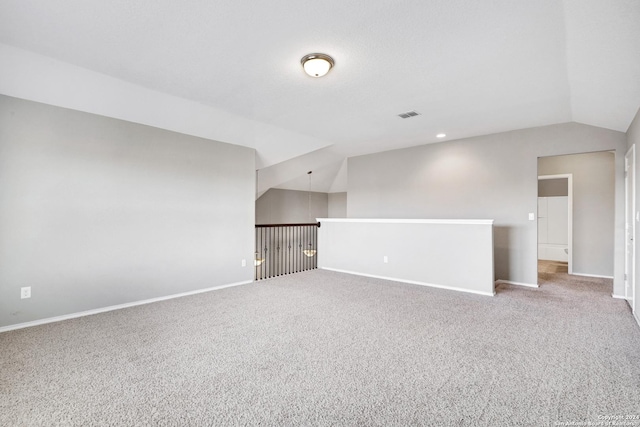 unfurnished room featuring lofted ceiling and carpet floors