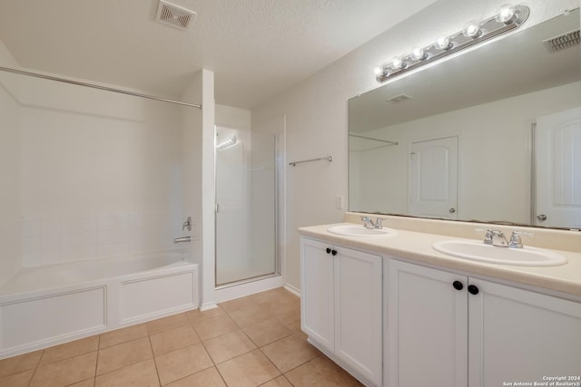 bathroom featuring tile patterned floors, separate shower and tub, vanity, and a textured ceiling