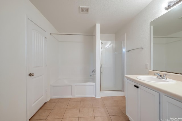 bathroom featuring tile patterned flooring, vanity, a textured ceiling, and independent shower and bath