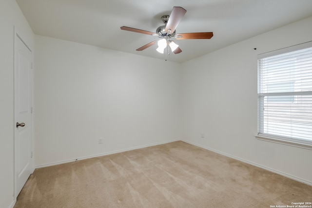 carpeted spare room with a wealth of natural light and ceiling fan