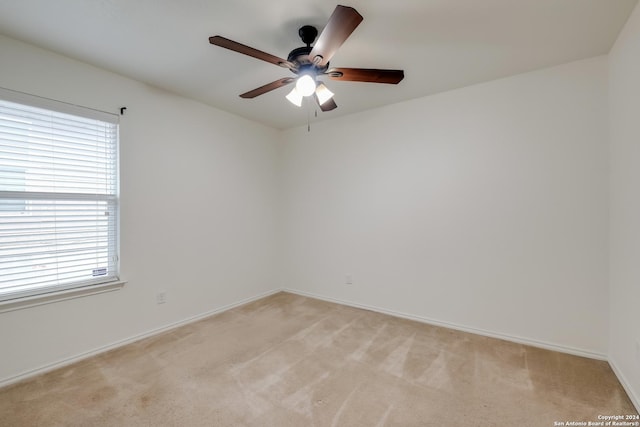 unfurnished room with ceiling fan, light carpet, and a wealth of natural light