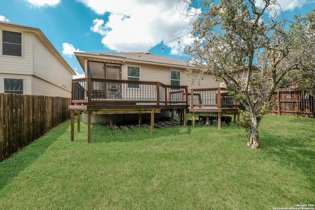 rear view of house with a yard and a deck