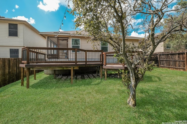 back of house featuring a sunroom, a yard, and a deck