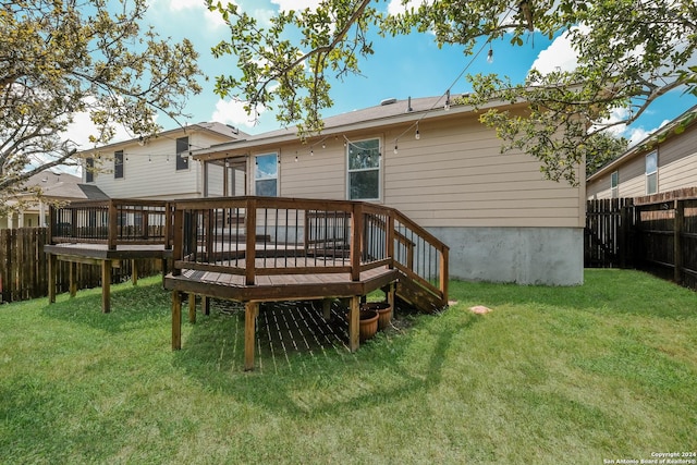 rear view of house featuring a lawn and a deck