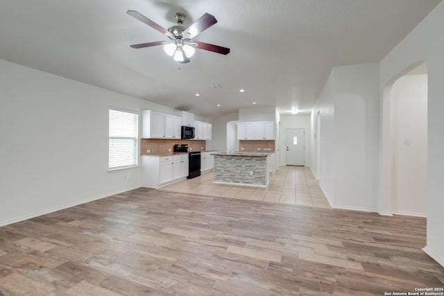 unfurnished living room featuring ceiling fan and light hardwood / wood-style flooring