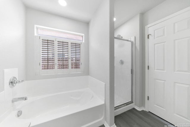 bathroom featuring hardwood / wood-style flooring and plus walk in shower