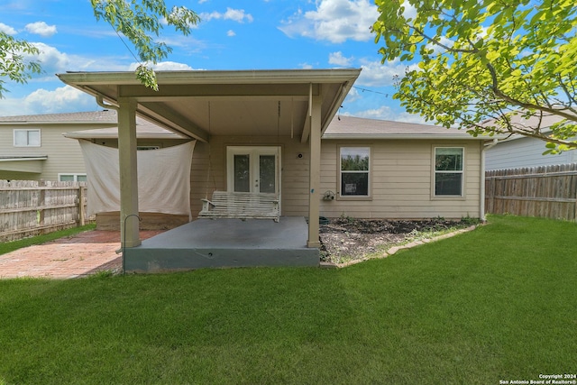 rear view of house with a yard, a patio, and french doors