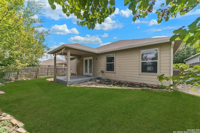 back of house with a yard, french doors, and a patio