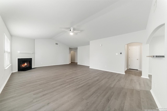 unfurnished living room with ceiling fan, light wood-type flooring, and vaulted ceiling