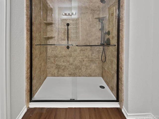 bathroom featuring hardwood / wood-style flooring and a shower with shower door