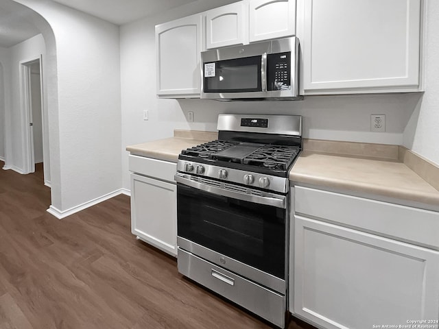 kitchen with white cabinets, dark hardwood / wood-style flooring, and stainless steel appliances