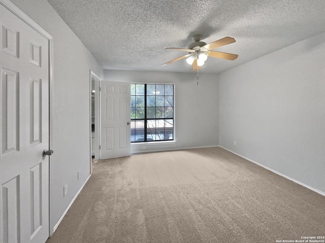 carpeted spare room with ceiling fan and a textured ceiling