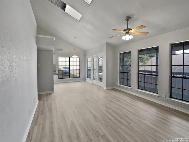 unfurnished living room with ceiling fan, plenty of natural light, light wood-type flooring, and french doors