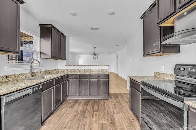 kitchen with light stone countertops, dark brown cabinets, sink, black appliances, and light hardwood / wood-style floors