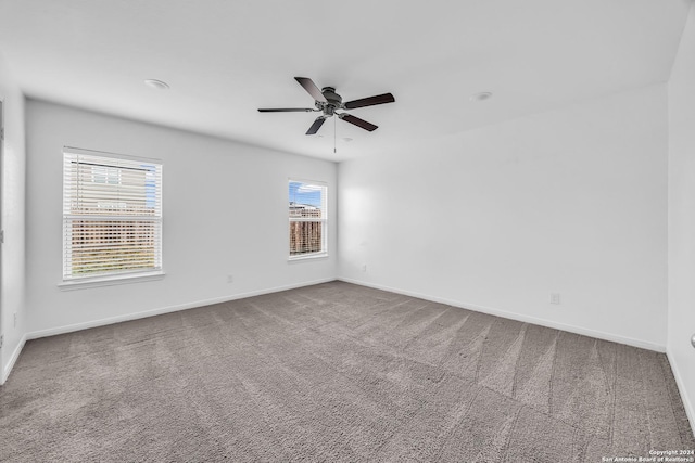 empty room with carpet flooring, plenty of natural light, and ceiling fan