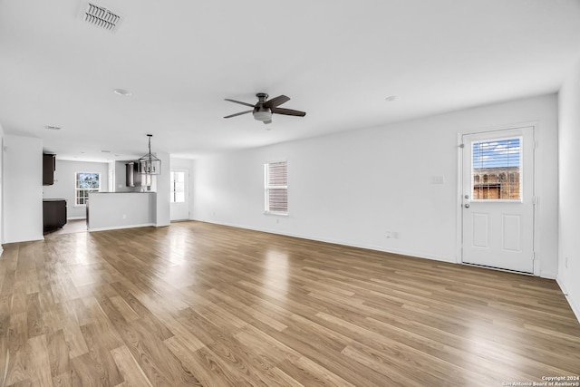 unfurnished living room featuring a wealth of natural light, light hardwood / wood-style floors, and ceiling fan