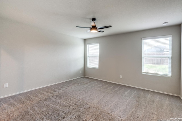 carpeted spare room featuring ceiling fan