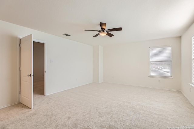 carpeted spare room featuring ceiling fan