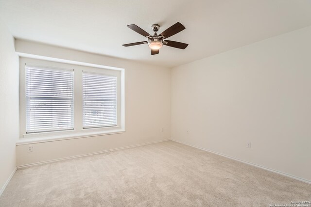 carpeted spare room with ceiling fan