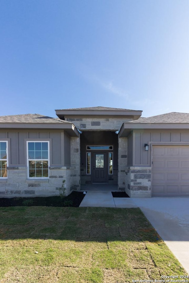 prairie-style house with a garage and a front lawn