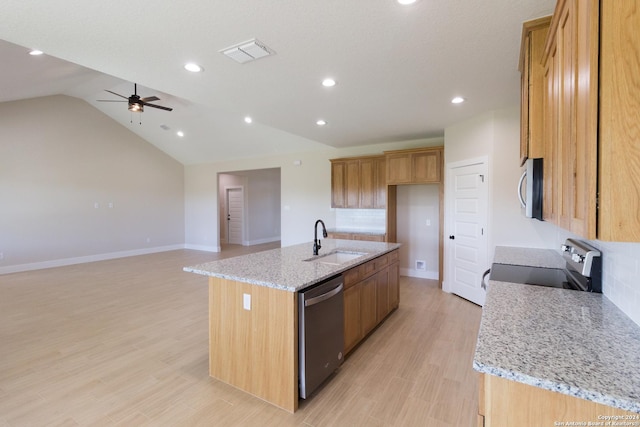 kitchen featuring appliances with stainless steel finishes, sink, light hardwood / wood-style floors, light stone countertops, and a center island with sink