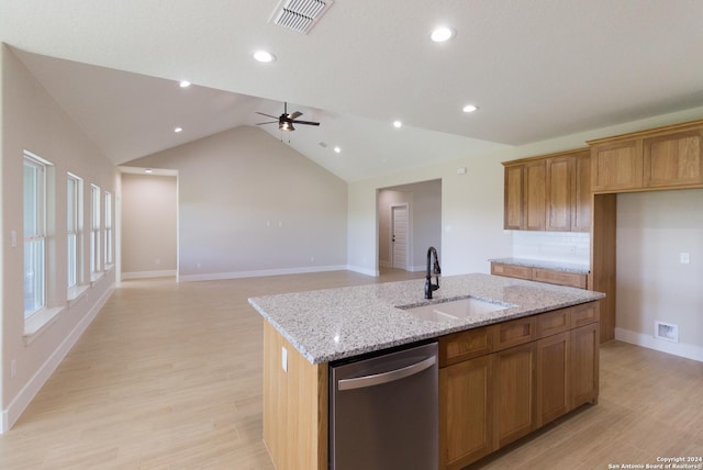 kitchen featuring an island with sink, sink, stainless steel dishwasher, light stone countertops, and light hardwood / wood-style flooring