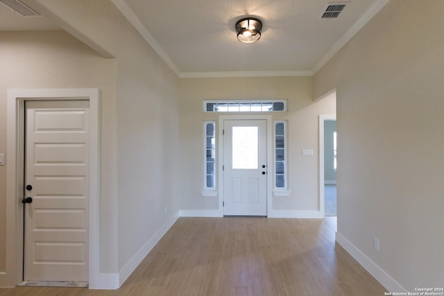 entryway featuring ornamental molding and light hardwood / wood-style flooring