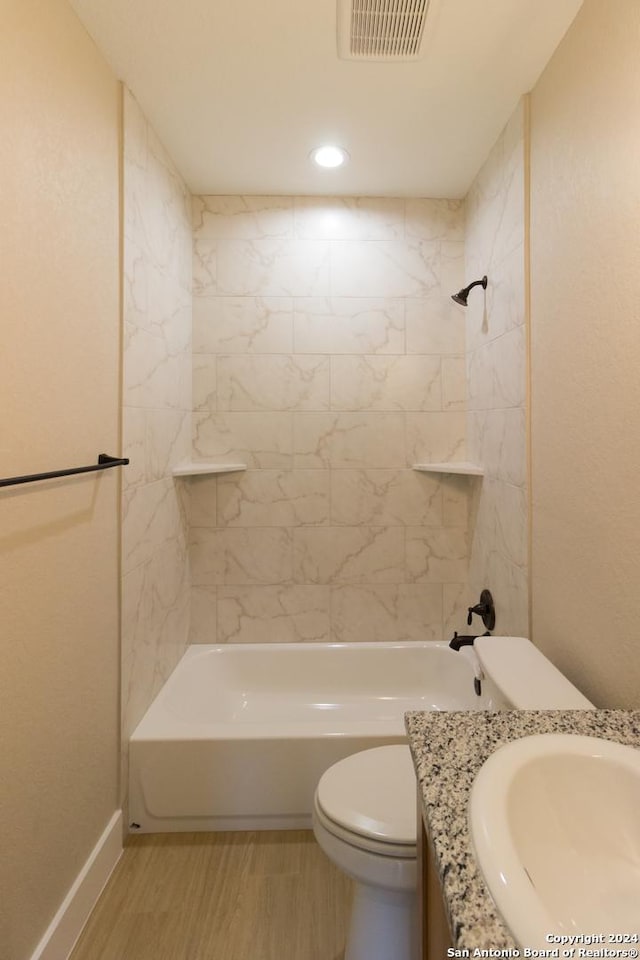 full bathroom with vanity, tiled shower / bath combo, wood-type flooring, and toilet