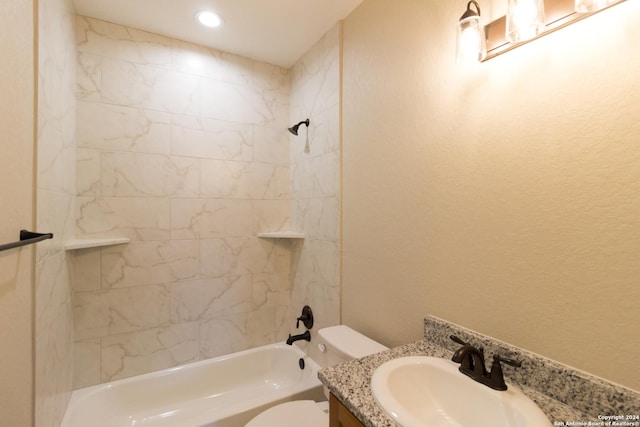 full bathroom with tiled shower / bath, vanity, and toilet