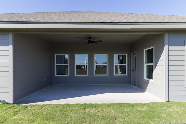 view of exterior entry featuring ceiling fan and a patio area