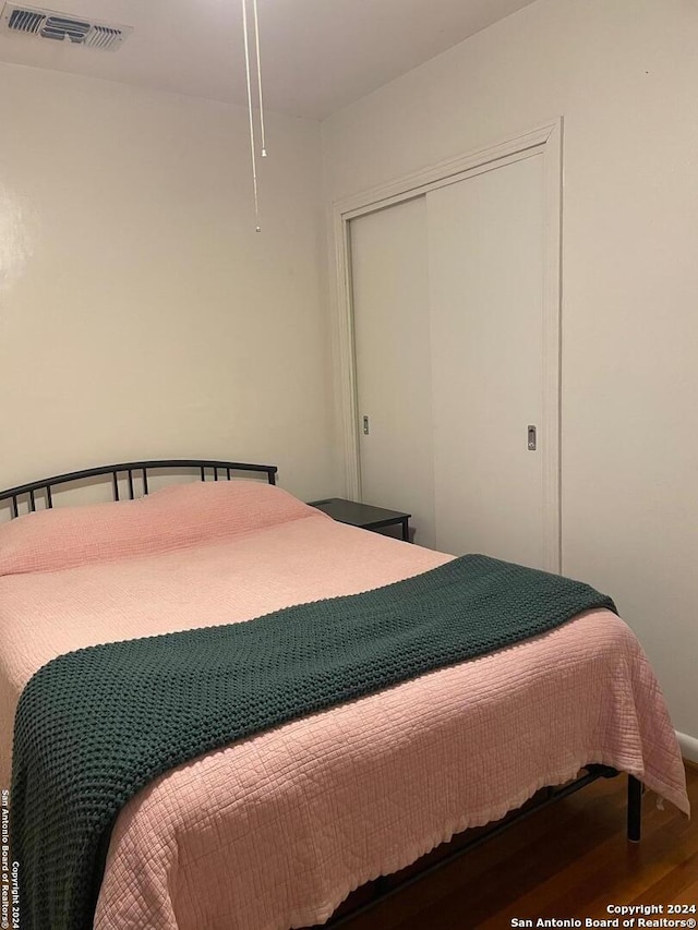 bedroom with hardwood / wood-style floors and a closet