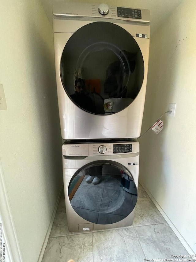 washroom featuring stacked washer and clothes dryer