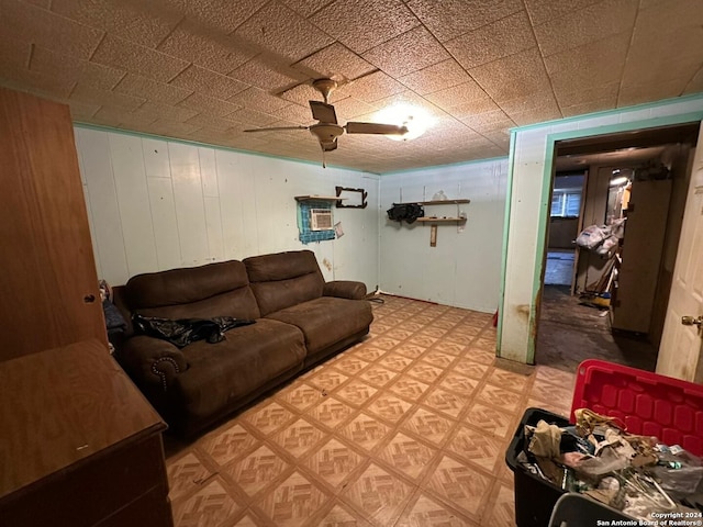 living room with ceiling fan and wooden walls