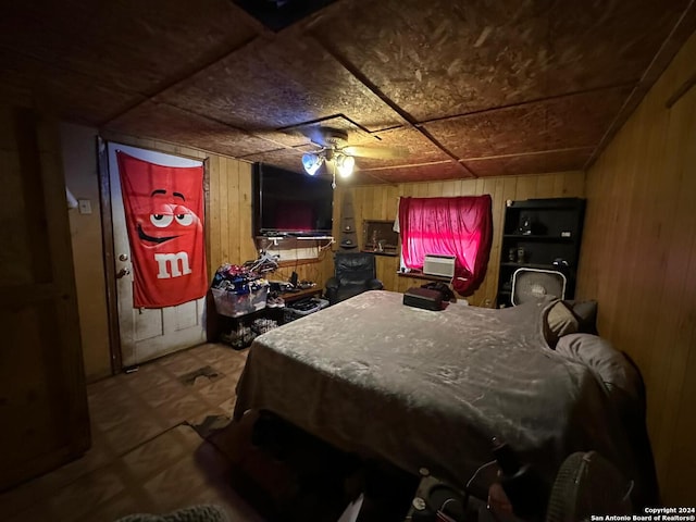 bedroom featuring ceiling fan and wood walls