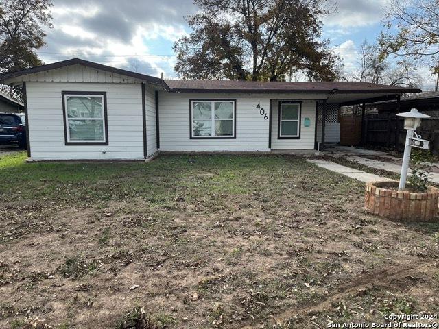 ranch-style home with a front yard and a carport