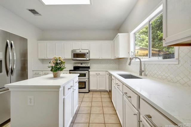 kitchen with white cabinetry, sink, backsplash, light tile patterned flooring, and appliances with stainless steel finishes