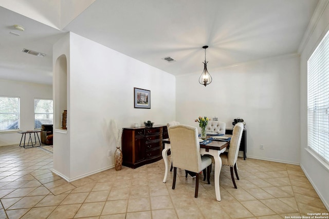 dining area featuring ornamental molding and light tile patterned flooring