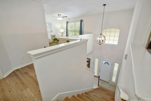 foyer entrance featuring ceiling fan with notable chandelier and light hardwood / wood-style flooring