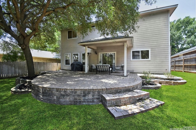 rear view of property featuring a patio area and a yard